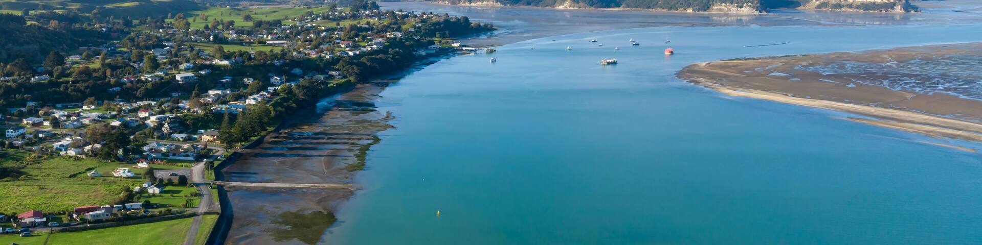 Aerial view of Kawhia Harbour, Kawhia, Waikato, New Zealand, showcasing the town's coastal location. The image highlights the natural beauty of the area, with its waterways and landscape.