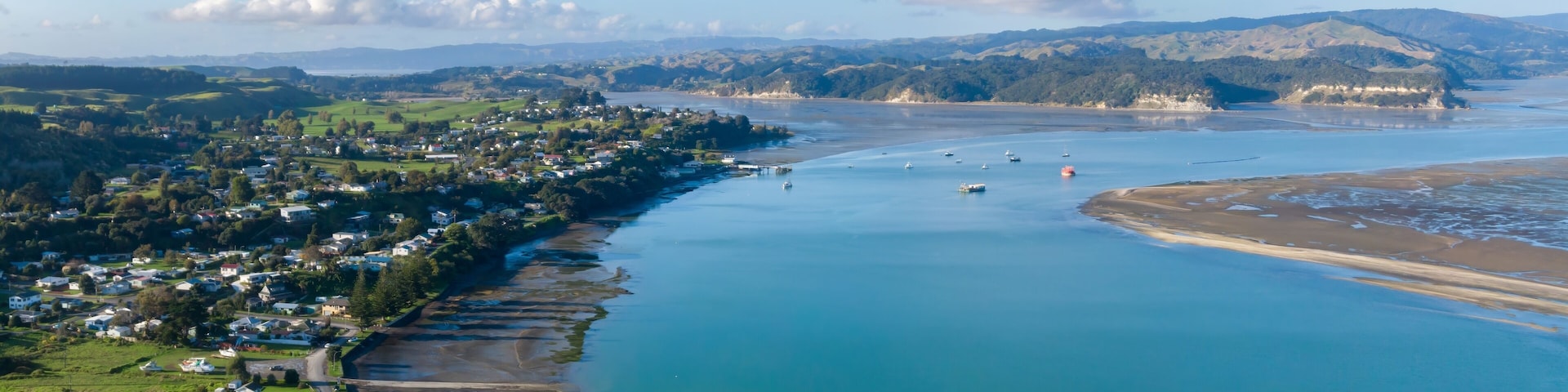 Aerial view of Kawhia Harbour, Kawhia, Waikato, New Zealand, showcasing the town's coastal location. The image highlights the natural beauty of the area, with its waterways and landscape.