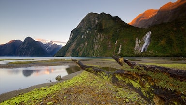 Fiordland National Park featuring a sunset, mountains and a waterfall