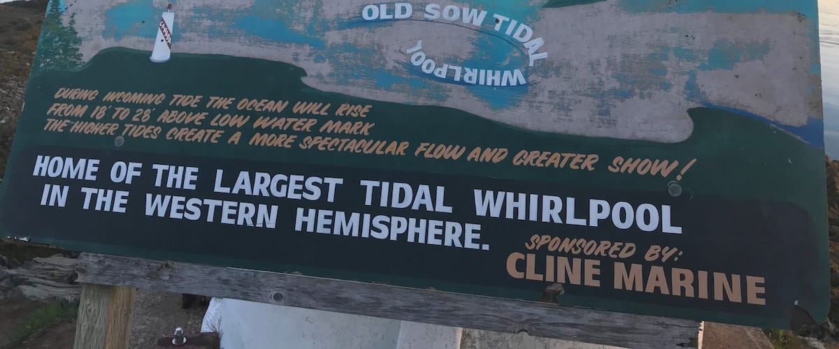 A sign welcoming visitors to Deer Island Point Park, mentioning the Old Sow Tidal Whirlpool and the largest tidal whirlpool in the western hemisphere.