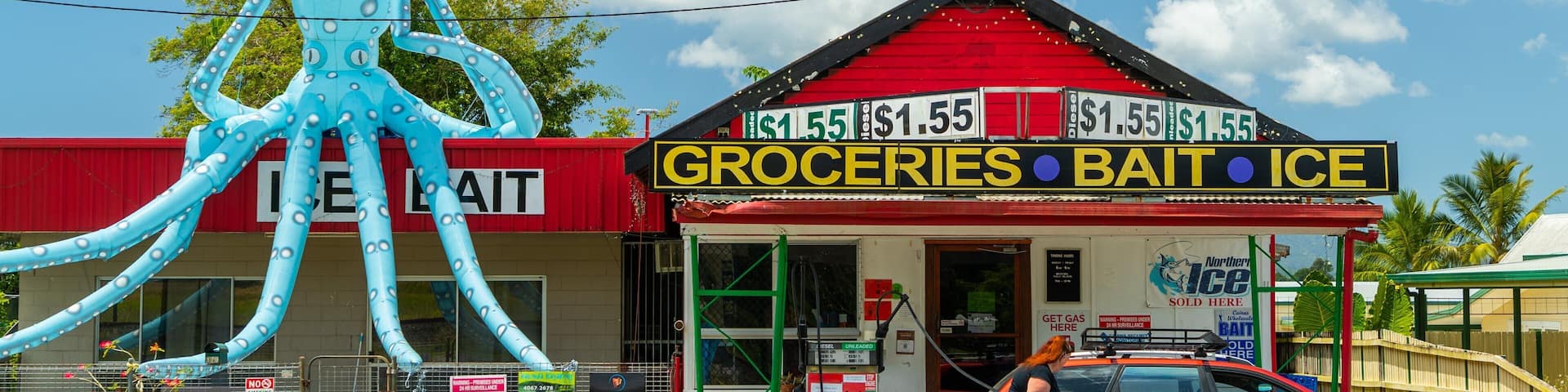Babinda featuring signage and a small town or village as well as an individual femail