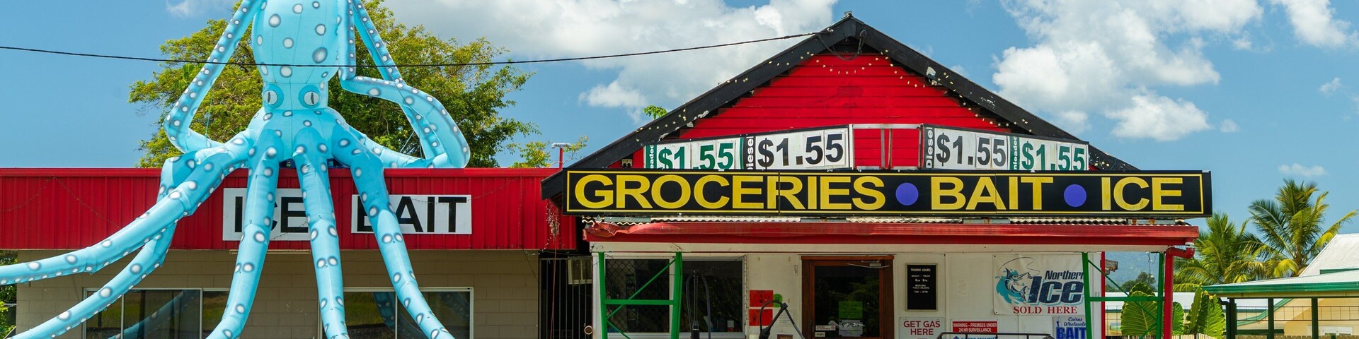 Babinda featuring signage and a small town or village as well as an individual femail