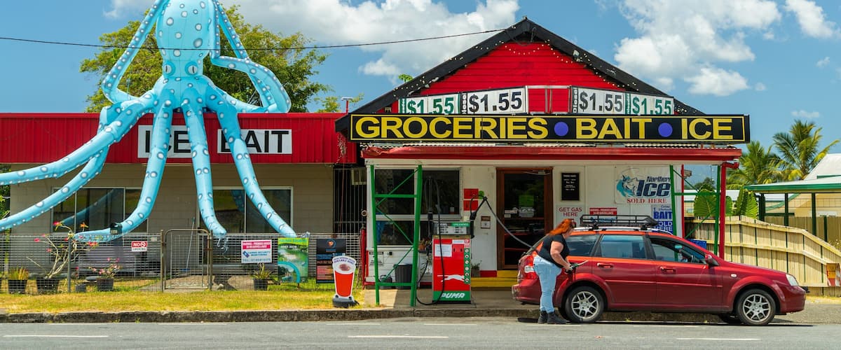 A store named 'Groceries Bait Ice' with a large inflatable octopus outside.