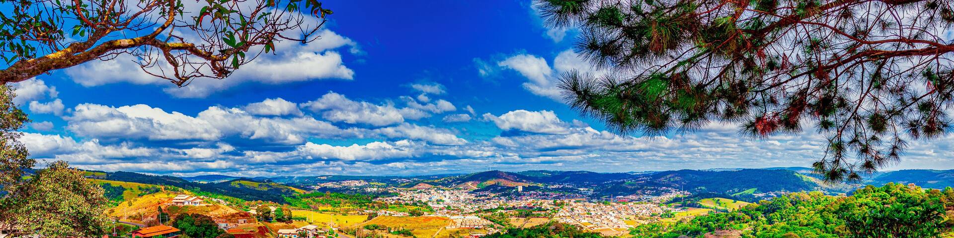 A panoramic view of a town nestled in a valley with a prominent road curving through it.