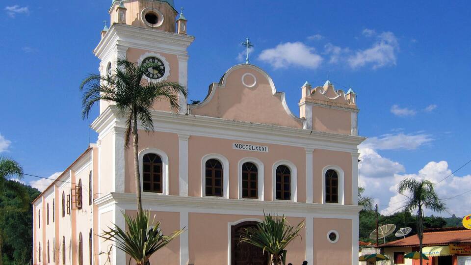 A pink church with a blue dome and a clock tower.