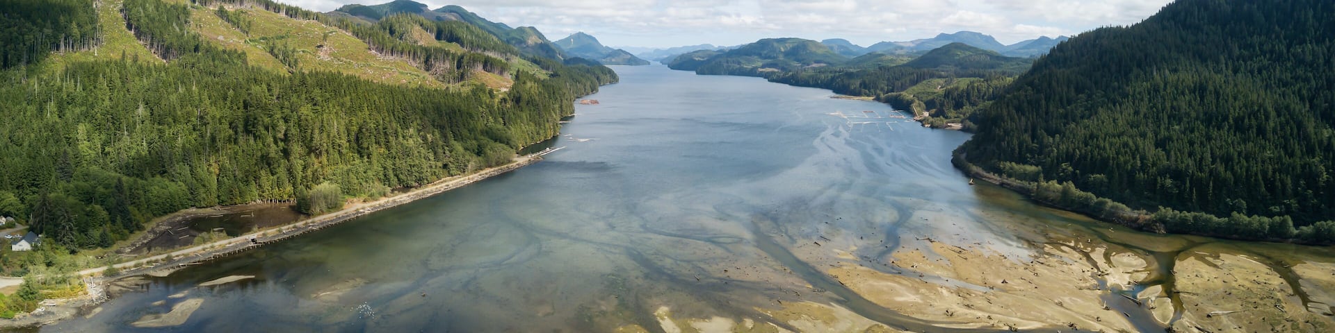 Aerial panoramic landscape view of an Ocean Inlet surrounded by mountains during a vibrant sunny summer day. Taken near Holberg, Northern Vancouver Island, BC, Canada.