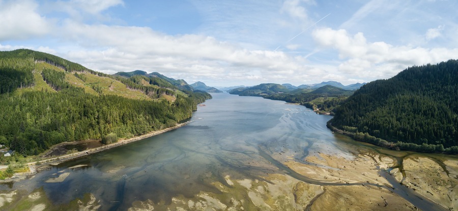 Aerial panoramic landscape view of an Ocean Inlet surrounded by mountains during a vibrant sunny summer day. Taken near Holberg, Northern Vancouver Island, BC, Canada.