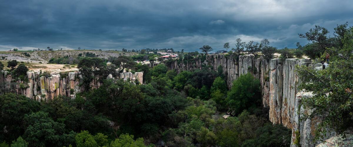 A rugged landscape with towering rock formations and dense greenery.