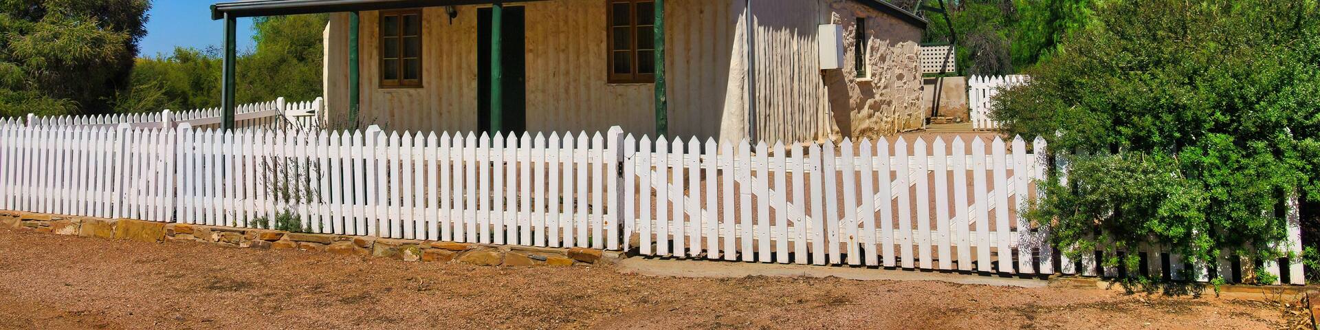 Traditional pioneer cottage made of vertical logs and stone, and with a roof of corrugated metal, in the outback town of Blinman, Flinders Ranges, South Australia