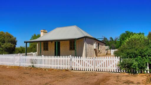 Traditional pioneer cottage made of vertical logs and stone, and with a roof of corrugated metal, in the outback town of Blinman, Flinders Ranges, South Australia