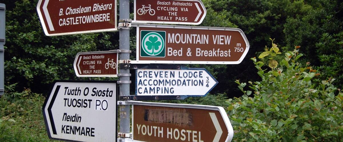 A directional signpost with multiple arrows pointing to various destinations including Rabach's Way, Castletownbere, Mountain View, Creveen Lodge, Tuath O Siosta, Tuosist P.O., and Kenmare.