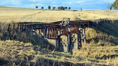Old abandoned wooden railway bridge over the Boorowa River, in rural central west NSW, Australia
