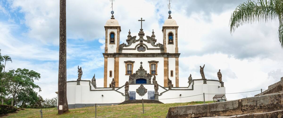 A historic church with two towers, a central dome, and statues on the facade.