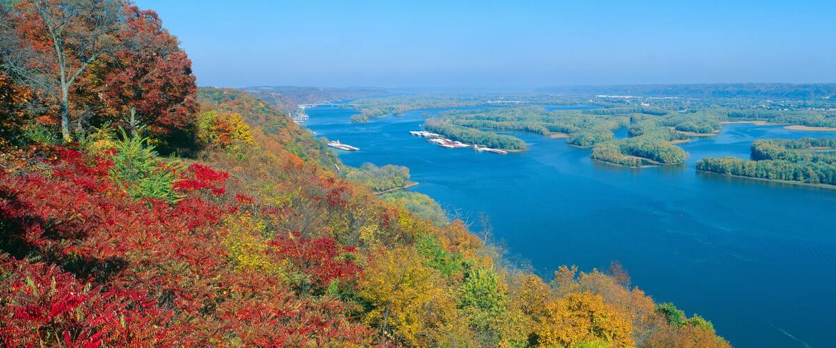 A river with several islands, surrounded by autumn-colored trees.