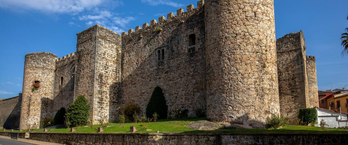 A historic stone castle with multiple towers and arched windows.