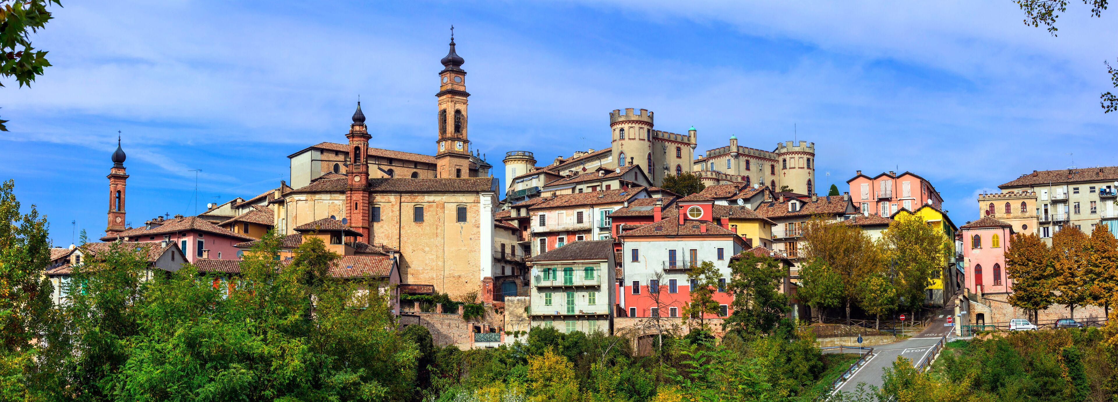 A historic town with colorful buildings, a prominent church tower, and a castle-like structure.