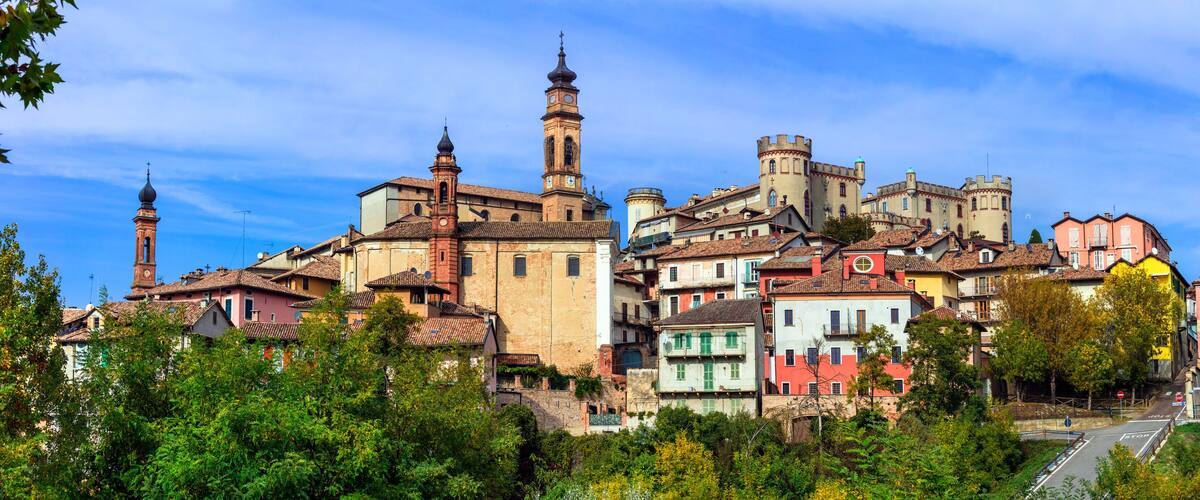 A historic town with colorful buildings, a prominent church tower, and a castle-like structure.