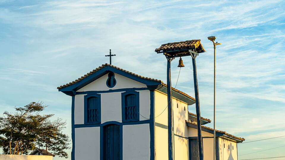 A small church with a bell tower and a cross on top.