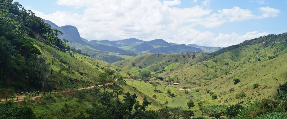 A lush green valley with rolling hills and a clear sky.