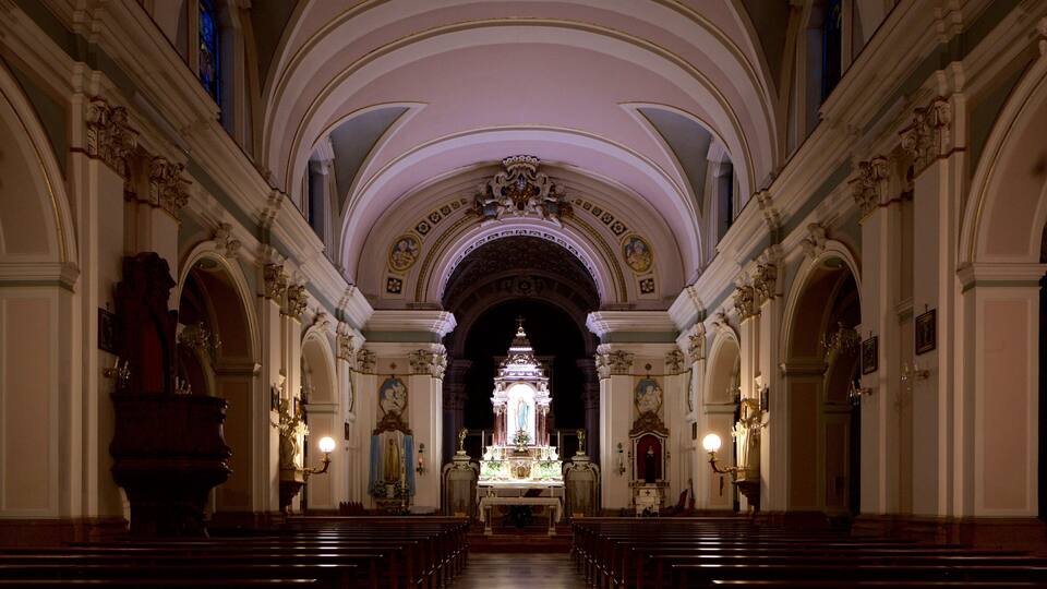 An ornate church interior with arched ceilings and rows of pews.