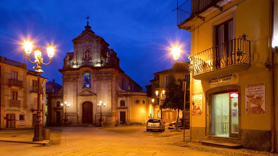 A historic church with a bell tower, street lamps, and a pizzeria.