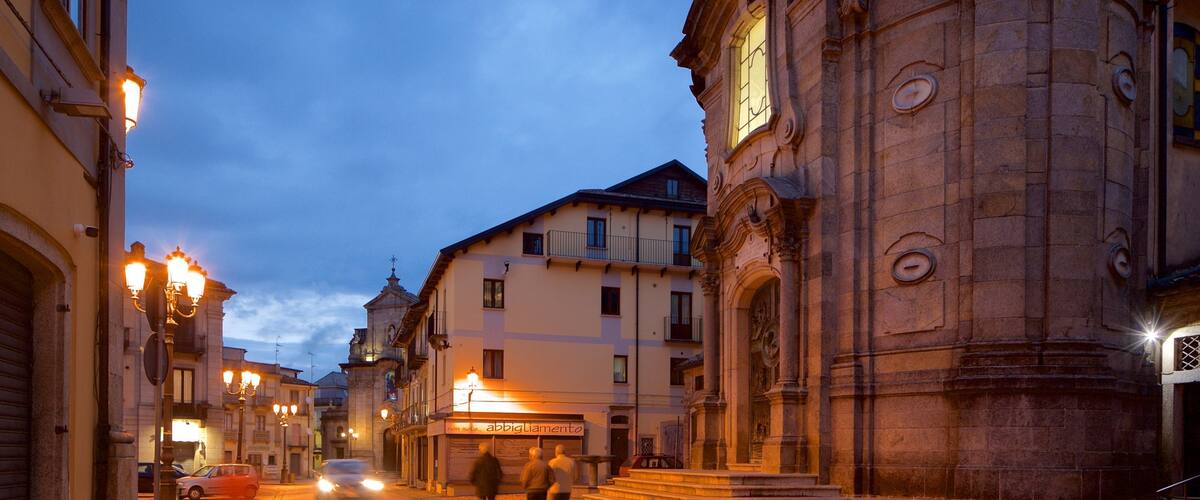 A cobblestone street at dusk with historic buildings and a prominent church.