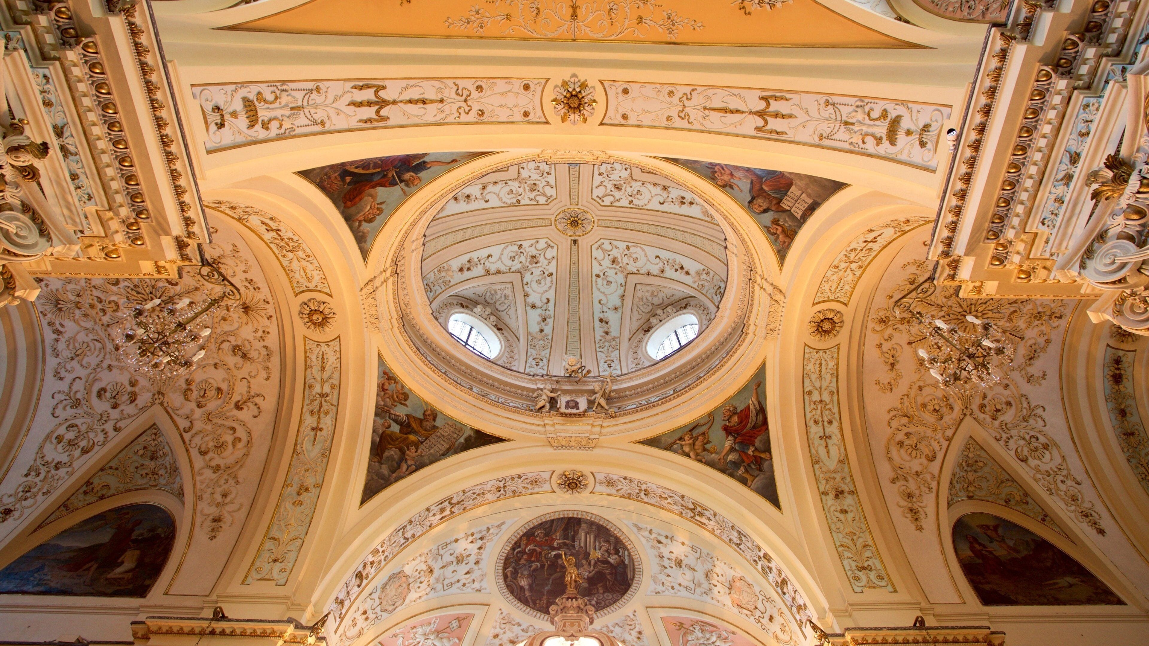 An ornate ceiling with intricate frescoes and gold accents.