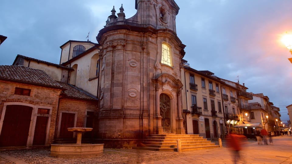 A historic church with a bell tower, a fountain, and cobblestone streets.