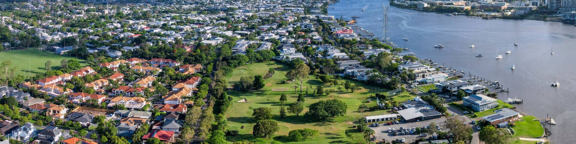 Aerial view of Brisbane River and Bulimba Golf Club with residential homes and greenery, Bulimba, Queensland, Australia.