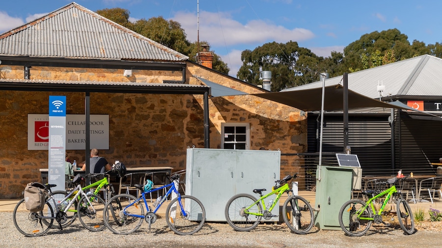 A stone building with a corrugated metal roof, bicycles parked in front, and a sign indicating free Wi-Fi.