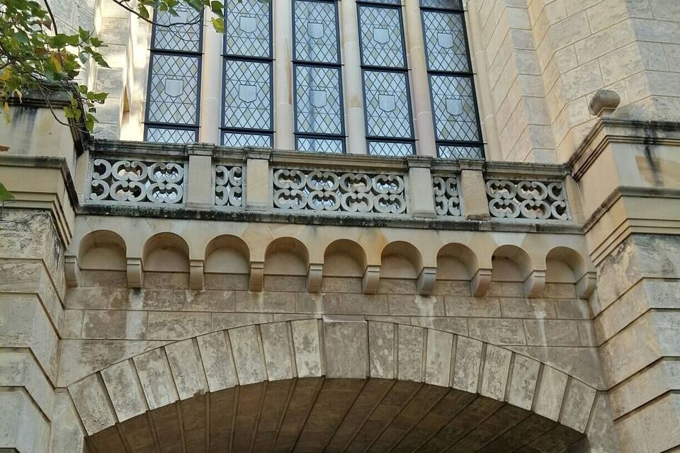 A stone archway with intricate carvings and a mosaic window above it.