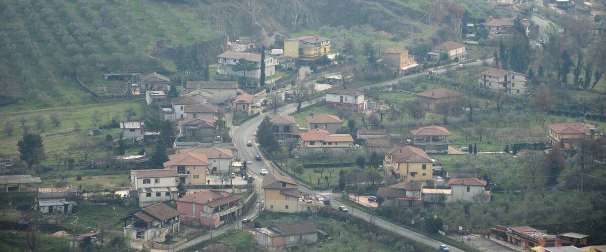 A hilly village with winding roads and scattered houses.