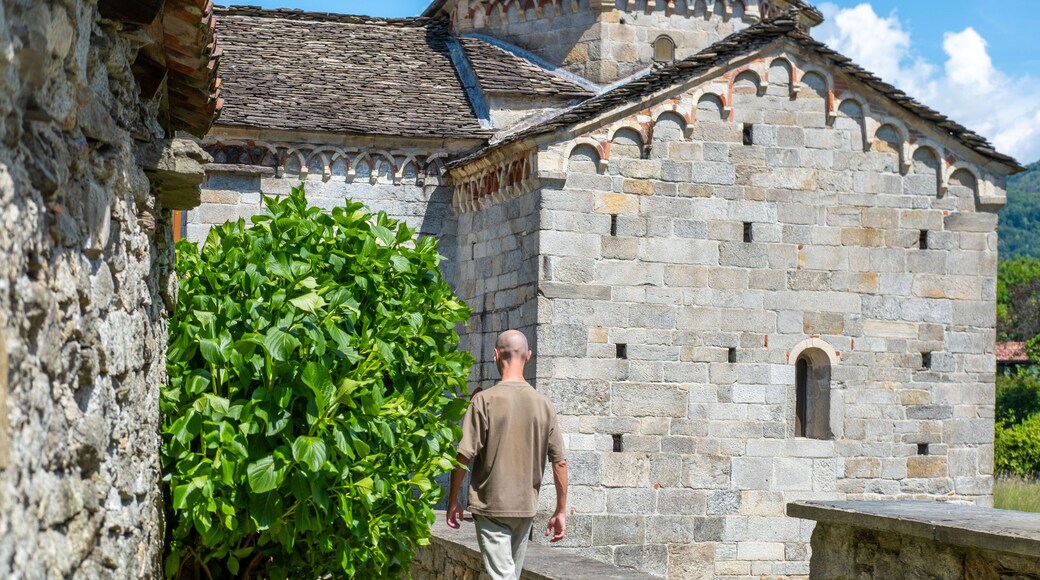 young man, Tourist Exploring Italy's Heritage Historic Church San Giovanni Battista 10th church, Picturesque Italian Montorfano village, timeless landmark