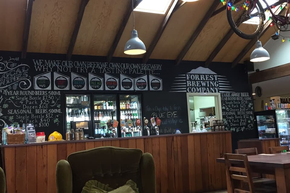 A cozy bar with wooden furniture and a chalkboard menu.