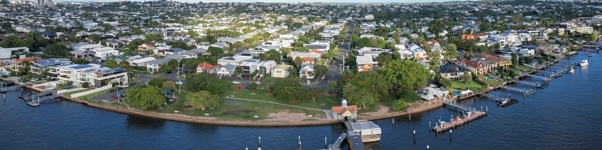 Aerial view of Hardcastle Park and Hawthorne ferry terminal along the Brisbane River with Queenslander houses and greenery, Hawthorne, Australia.