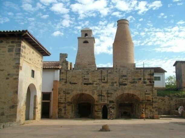 A historic stone building with a bell tower and arched doorways.