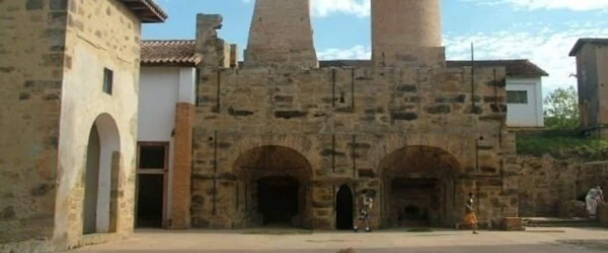 A historic stone building with a bell tower and arched doorways.