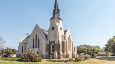 Uma igreja com um campanário pontiagudo e uma torre do relógio.