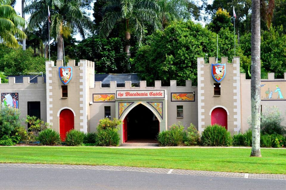 A castle-like building with a red door and a sign reading "the Macanogam Castle."