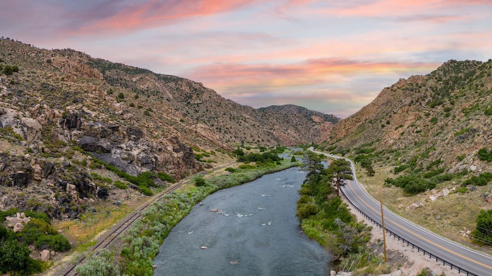 A winding river through a rocky canyon with a road on one side and a railway on the other.