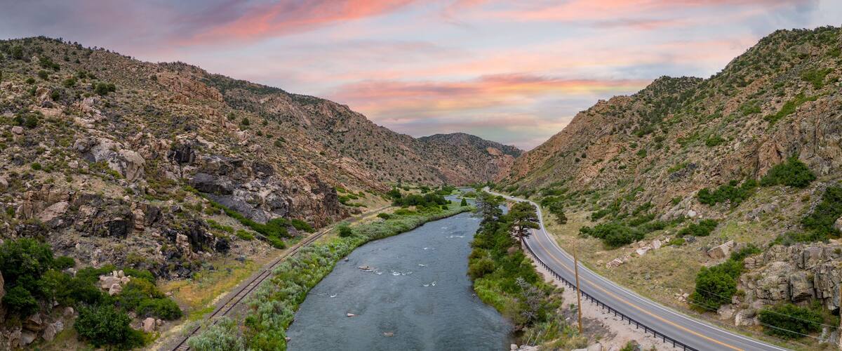 A winding river through a rocky canyon with a road on one side and a railway on the other.