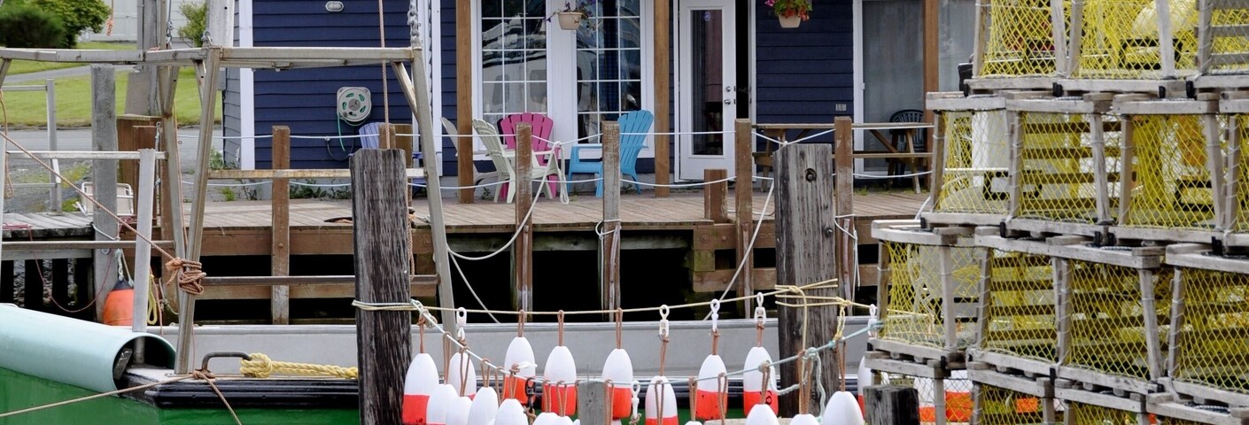 Un muelle con boyas y una casa con balcón.