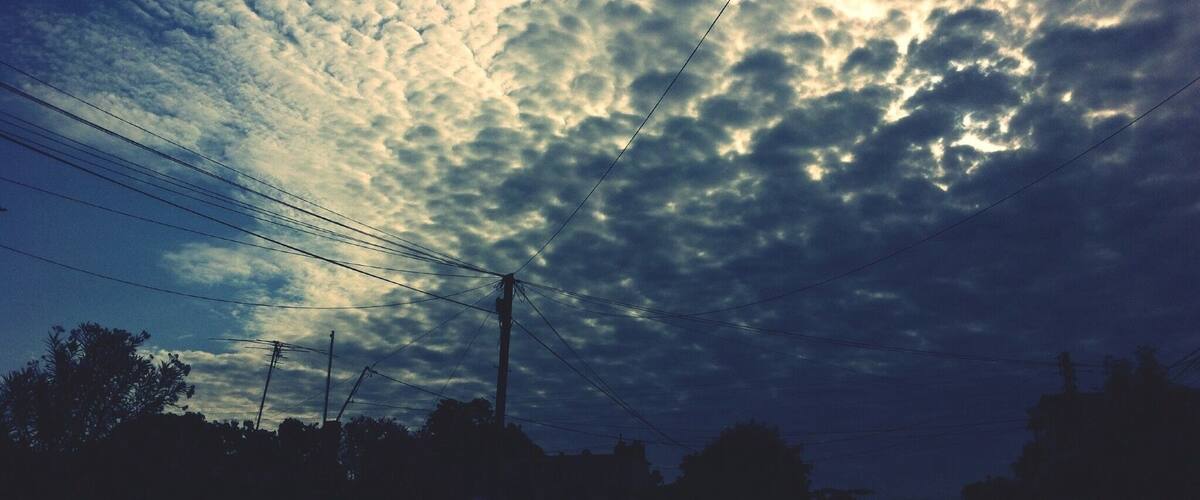 A sky filled with clouds and power lines.