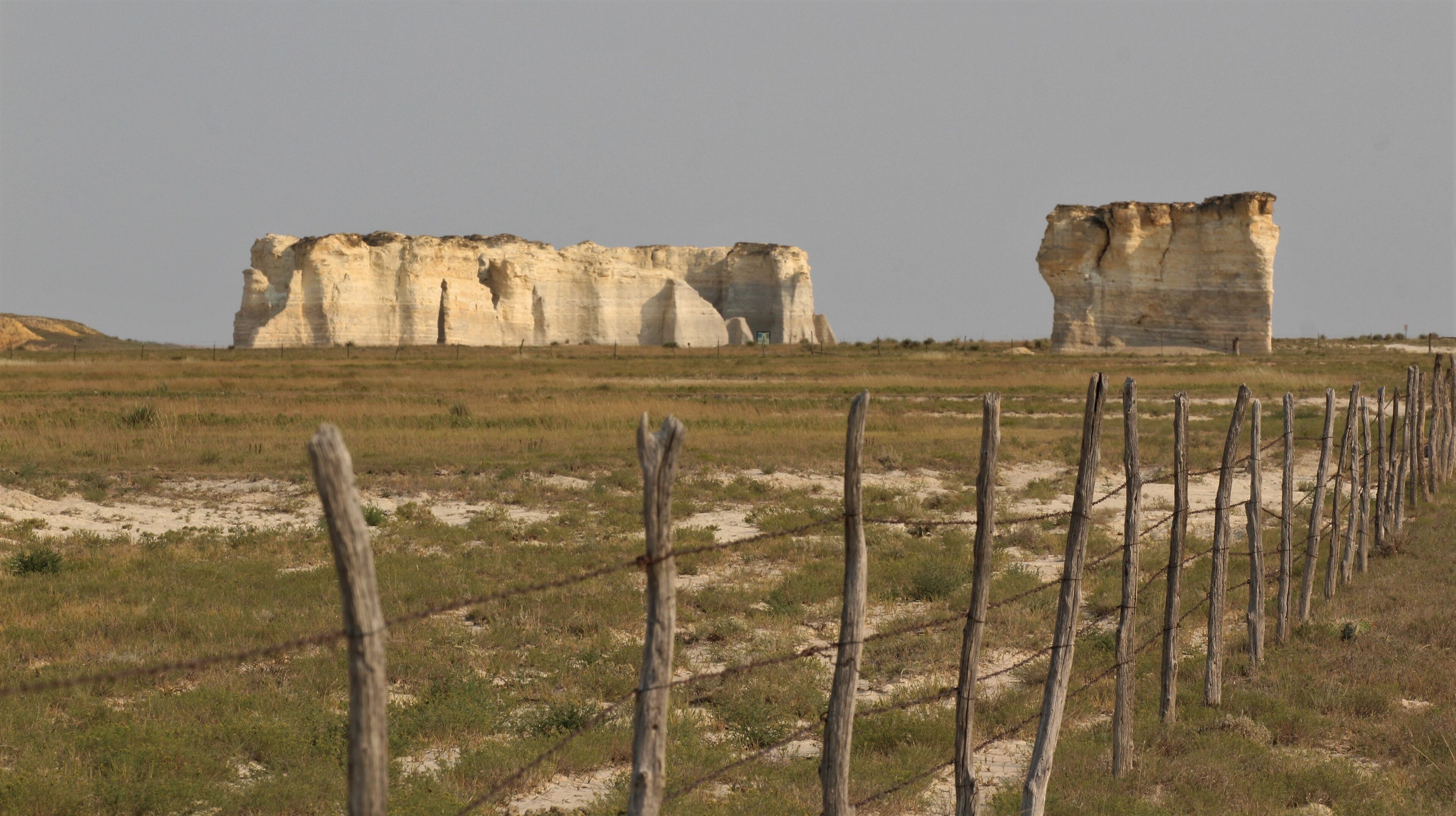 A landscape with large rock formations and a barbed wire fence.