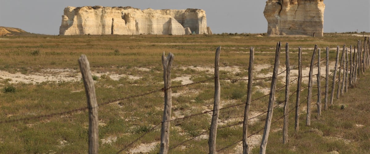A landscape with large rock formations and a barbed wire fence.