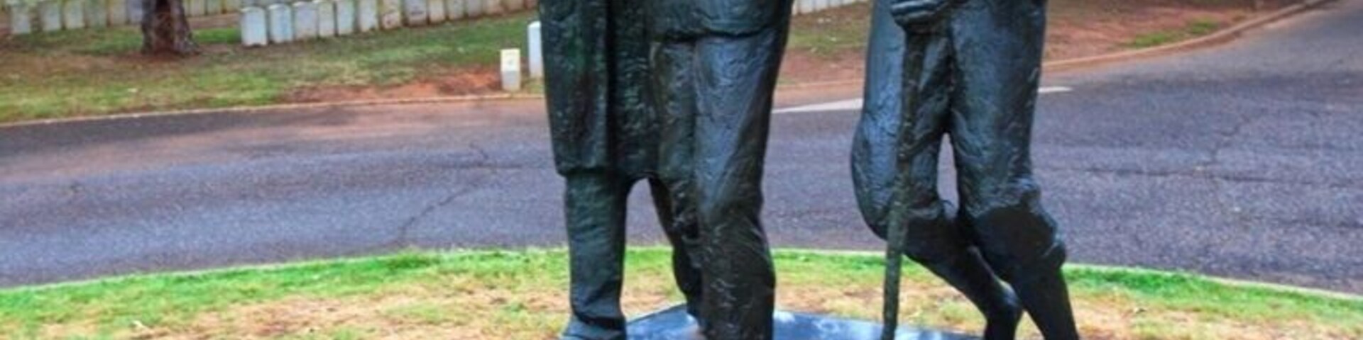 President Jimmy Carter, who had worked toward's Andersonville's inclusion in the National Park System, encouraged the State of Georgia to place a monument at the park.
Dedicated on Memorial Day 1976, the Georgia Monument serves as a memorial to all American prisoners of war.
In his own words, sculptor William Thompson described his imagery and intent in designing the Georgia Monument:
In creating a sculpture for Andersonville National Historic Site, it was my intention to design a monument which is sculpturally strong and humanly moving.
This sculpture is dedicated to all American prisoners involved in all American wars over our country's birth up to the present. The sculpture is designed to have a universal quality, and no reference to any particular uniform or specific details have been made. The accent has been placed on the inner struggle and strength of the prisoners.
The statue is intended to speak directly to the viewer in its formal sculpture statement, and about the strength of brotherhood and man's dependence upon God, in its symbolism.
The placement of the figures marching in a broken line is to call to mind the formations that all prison camps require. The placement of the prisoners on the incline plane of the granite base emphasizes the fact that it is an uphill struggle just to survive under prison camp conditions. These men have exhausted their human resources and now look beyond one another to God for strength. (Note description on the base.)
The two figures in front are united by the overlapping of their arms, which accent the supportive nature of the group. The support of a fellow prisoner often made the difference between life and death, and the sculpture composition and gesture of the monument is to bring this fact into dramatic focus. Men are often captured as a result of their battle wounds, and others develop maladies and injuries during their imprisonment, therefore, I decided to depict my prisoners with wounds.