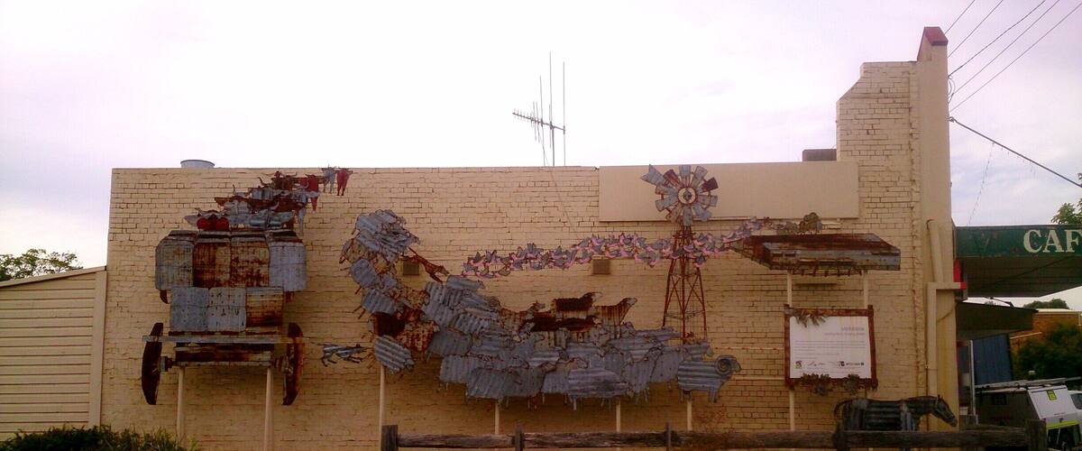 A building with a brick facade, a windmill, and a sign that reads "CAFE".