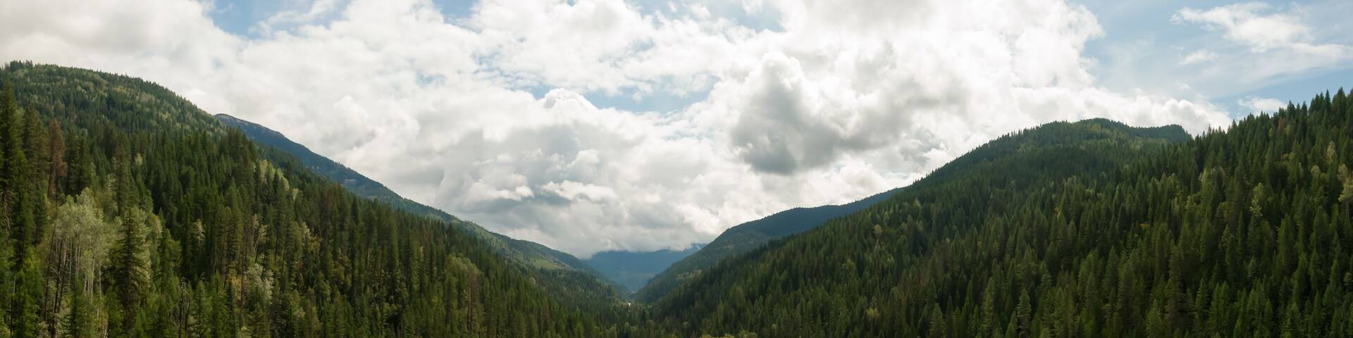 Aerial Panoramic View of a Scenic Highway in the Valley surrounded by Canadian Mountain Landscape. Taken near Salmo, British Columbia, Canada.