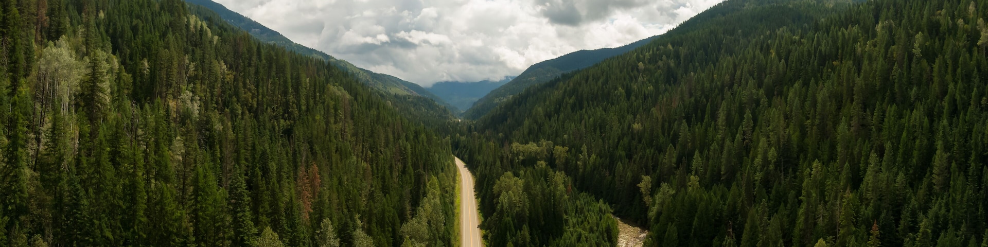 Aerial Panoramic View of a Scenic Highway in the Valley surrounded by Canadian Mountain Landscape. Taken near Salmo, British Columbia, Canada.