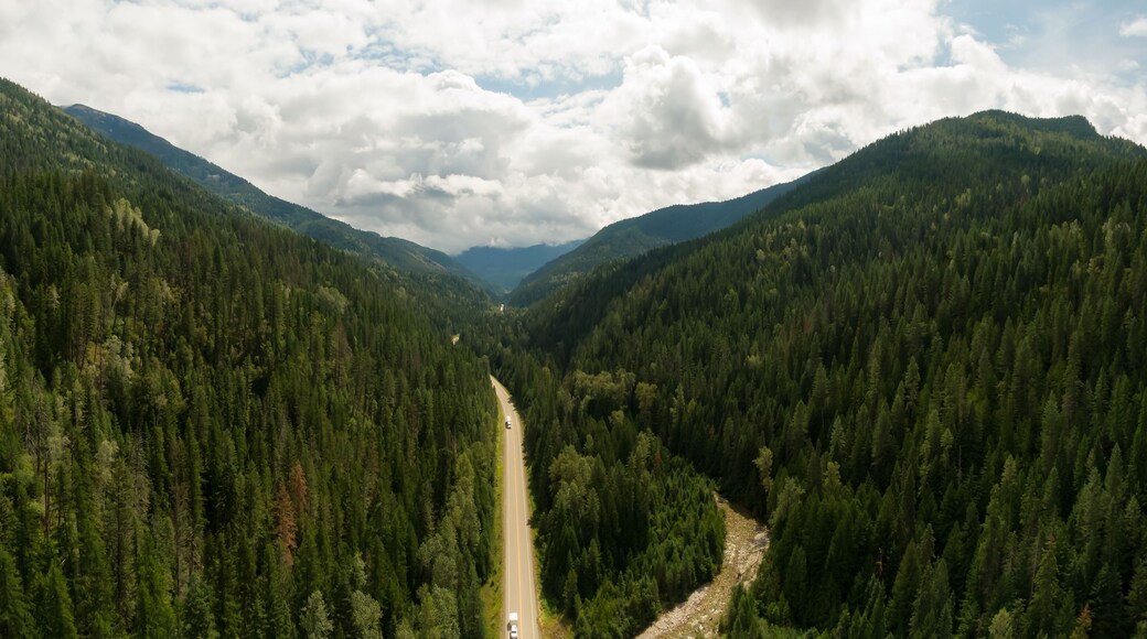 Aerial Panoramic View of a Scenic Highway in the Valley surrounded by Canadian Mountain Landscape. Taken near Salmo, British Columbia, Canada.